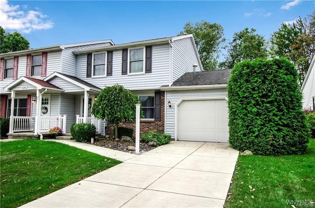 view of property with brick siding, covered porch, an attached garage, driveway, and a front lawn