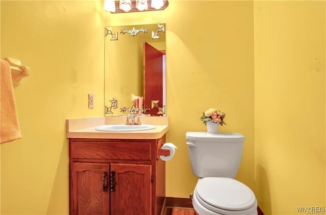 half bathroom featuring toilet and vanity