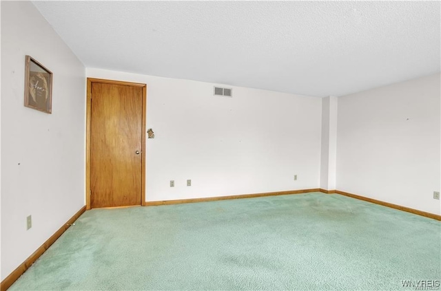 empty room featuring baseboards, visible vents, a textured ceiling, and light colored carpet