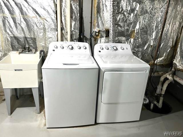 laundry room with laundry area, separate washer and dryer, and a sink