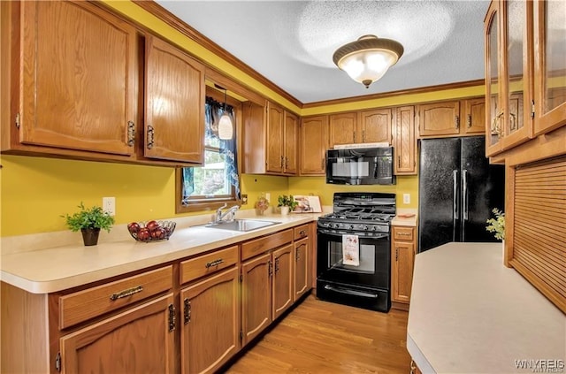 kitchen featuring black appliances, light countertops, a sink, and brown cabinetry