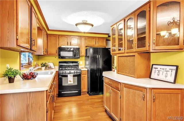 kitchen with glass insert cabinets, brown cabinets, light countertops, and black appliances