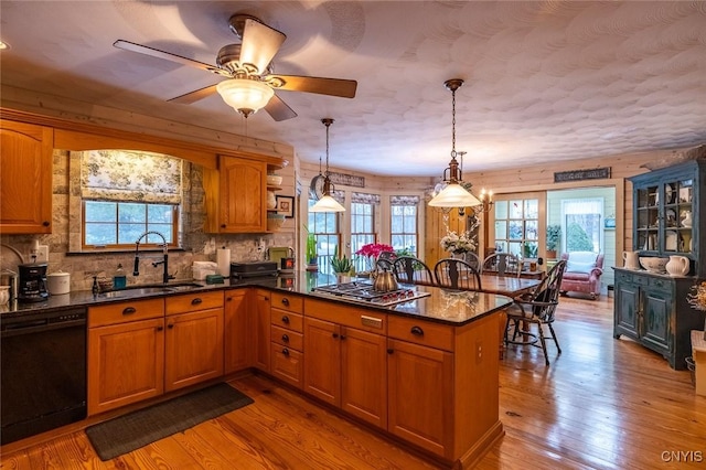 kitchen featuring light wood-type flooring, stainless steel gas stovetop, dishwasher, and a sink