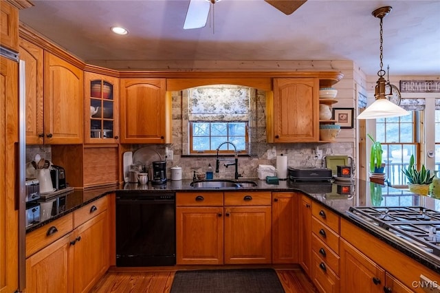 kitchen featuring black dishwasher, decorative backsplash, a sink, and stainless steel gas stovetop