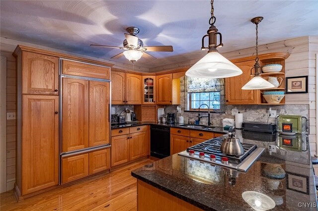 kitchen featuring black dishwasher, brown cabinets, stainless steel gas cooktop, a sink, and light wood-type flooring