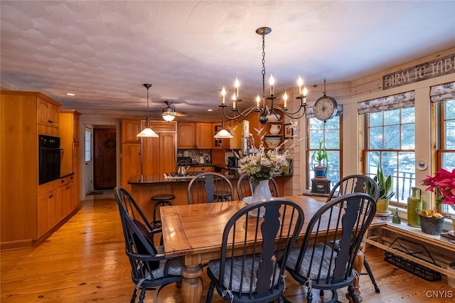 dining room with light wood-type flooring and an inviting chandelier