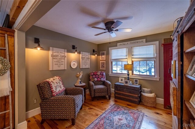 sitting room with light wood finished floors, ceiling fan, and baseboards