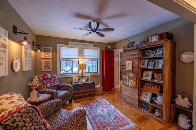 living area featuring light wood-style flooring and ceiling fan