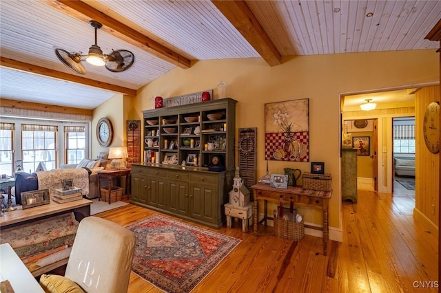 living area featuring vaulted ceiling with beams, ceiling fan, wooden ceiling, baseboards, and light wood-style floors