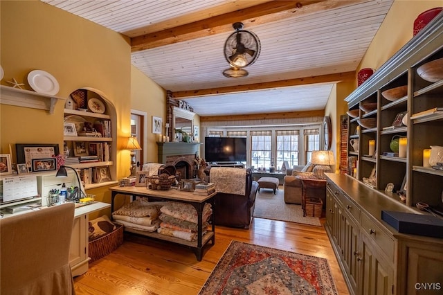 sitting room featuring wooden ceiling, light wood finished floors, a brick fireplace, and beam ceiling