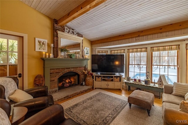 living room with lofted ceiling with beams, a fireplace, and wood finished floors