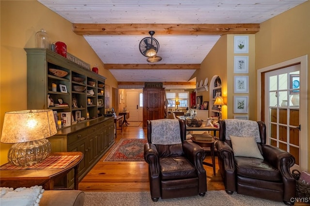 living area with lofted ceiling with beams, a healthy amount of sunlight, wood ceiling, and wood finished floors