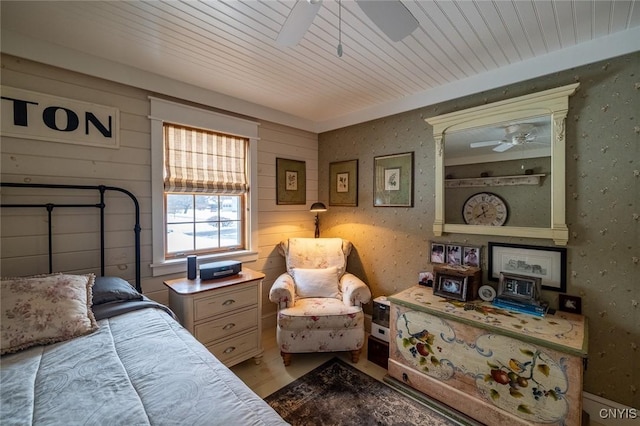 bedroom with ceiling fan, wood ceiling, and wallpapered walls