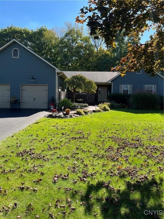 single story home featuring driveway, a front lawn, and an attached garage