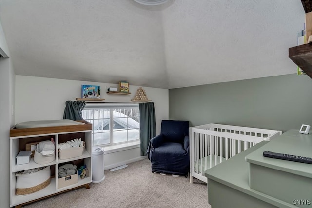 bedroom with carpet floors, vaulted ceiling, a textured ceiling, and baseboards