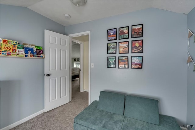 sitting room featuring carpet flooring, vaulted ceiling, and baseboards