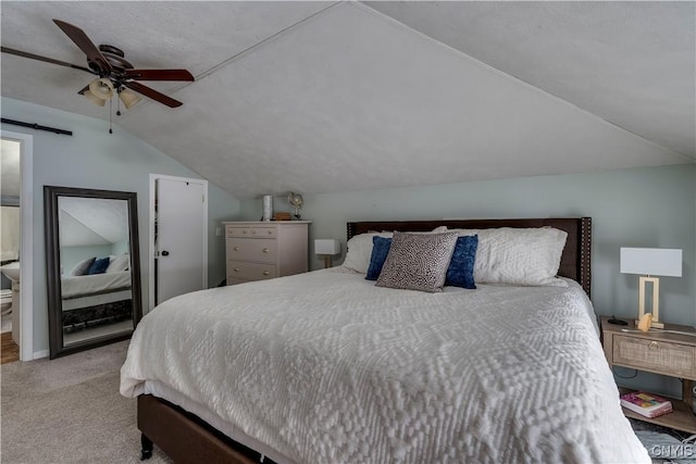 bedroom featuring light carpet, a barn door, a ceiling fan, and lofted ceiling