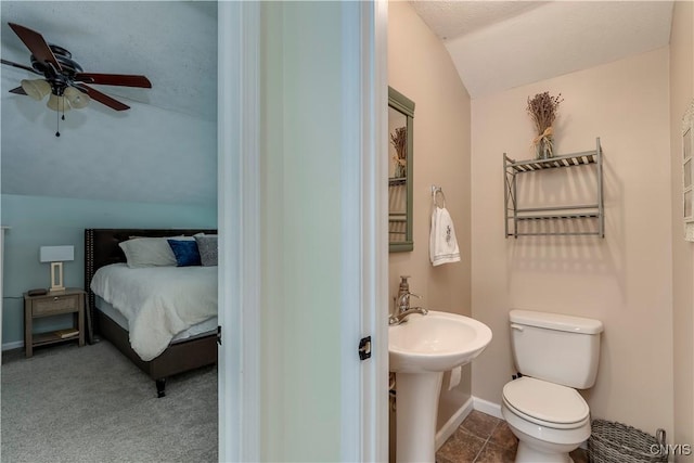 bathroom featuring lofted ceiling, toilet, ensuite bathroom, ceiling fan, and baseboards