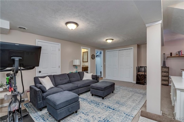 living area featuring visible vents, a textured ceiling, and light colored carpet