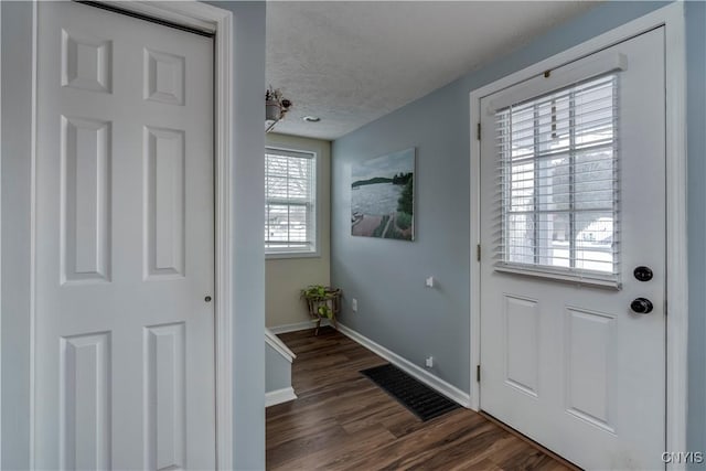 doorway with baseboards, visible vents, dark wood-style flooring, and a textured ceiling