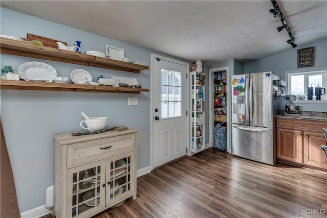 kitchen featuring a textured ceiling, stainless steel fridge with ice dispenser, open shelves, dark wood finished floors, and track lighting