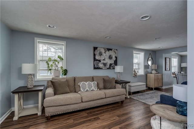 living area with a textured ceiling, dark wood-type flooring, recessed lighting, and baseboards