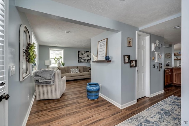 interior space with baseboards, dark wood-type flooring, and a textured ceiling