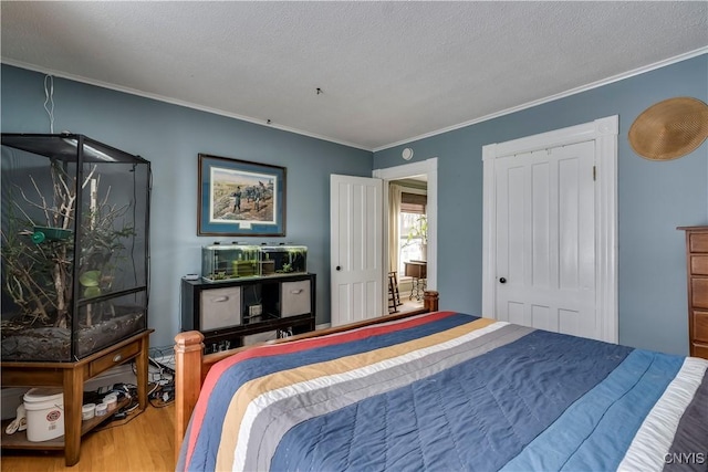 bedroom with crown molding, a closet, and wood finished floors