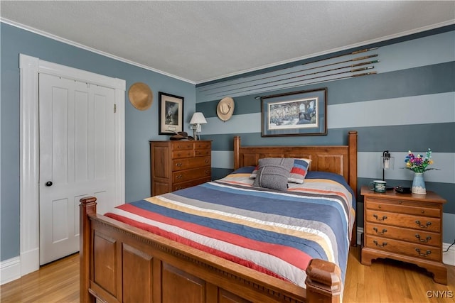 bedroom featuring a textured ceiling, light wood-type flooring, and crown molding