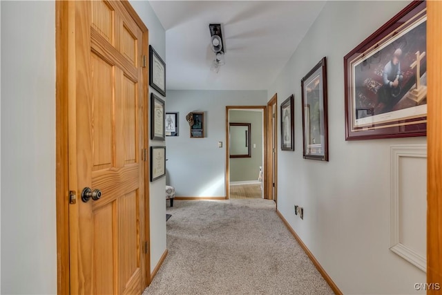 hallway featuring baseboards and carpet floors