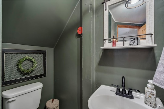 bathroom with toilet, a sink, and lofted ceiling