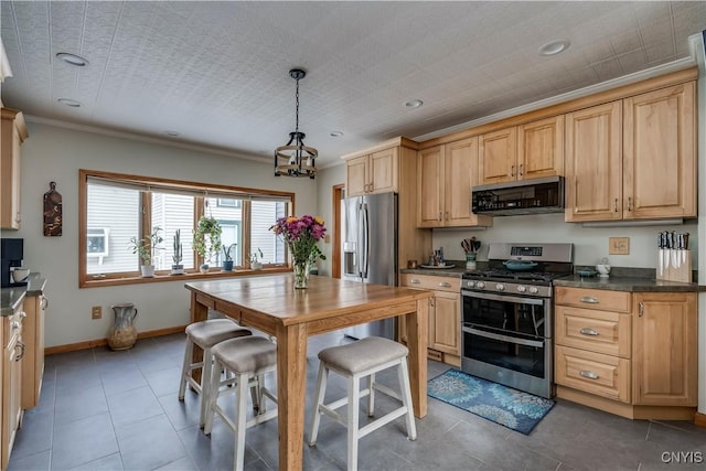 kitchen featuring baseboards, a chandelier, light tile patterned floors, dark countertops, and stainless steel appliances