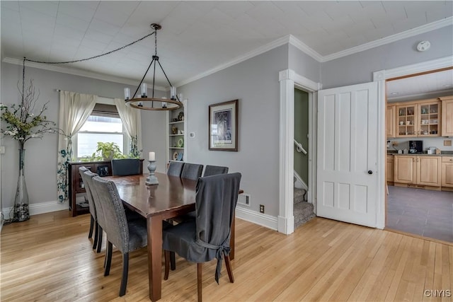 dining space featuring light wood-style flooring, stairs, and ornamental molding