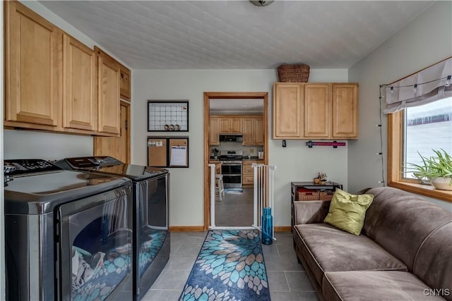 clothes washing area featuring cabinet space, baseboards, separate washer and dryer, and light tile patterned flooring