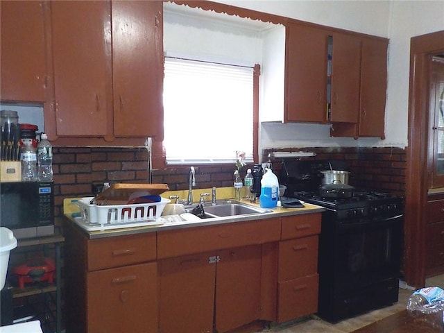 kitchen with decorative backsplash, stainless steel microwave, brown cabinets, a sink, and gas stove