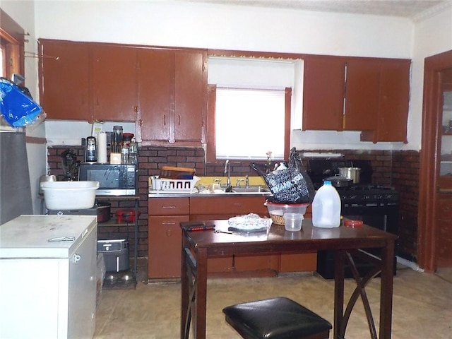 kitchen featuring stainless steel microwave, a sink, and a breakfast bar area