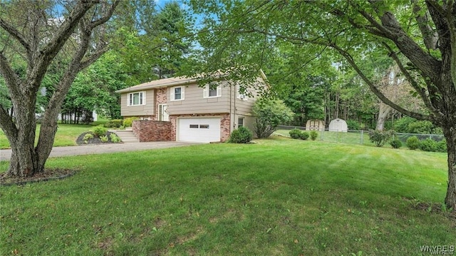 view of front of house with brick siding, concrete driveway, an attached garage, a front yard, and fence