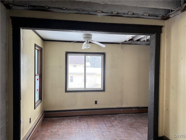 spare room featuring hardwood / wood-style floors, baseboard heating, and a ceiling fan