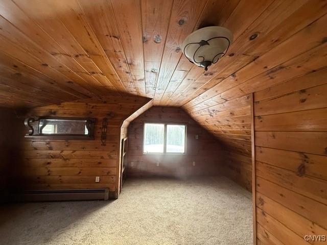 additional living space featuring carpet floors, a baseboard heating unit, wood walls, vaulted ceiling, and wooden ceiling