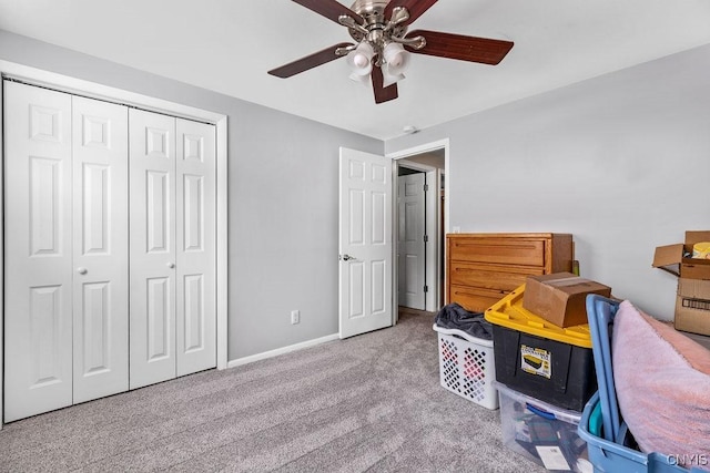 carpeted bedroom featuring a closet, ceiling fan, and baseboards