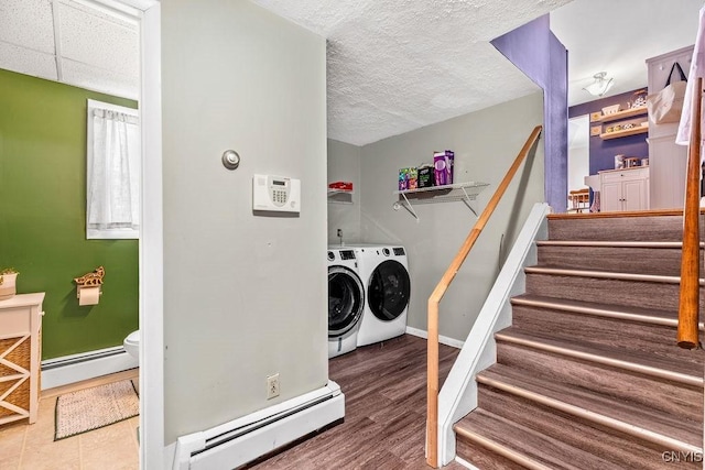 laundry room with laundry area, baseboard heating, washer and clothes dryer, and baseboards