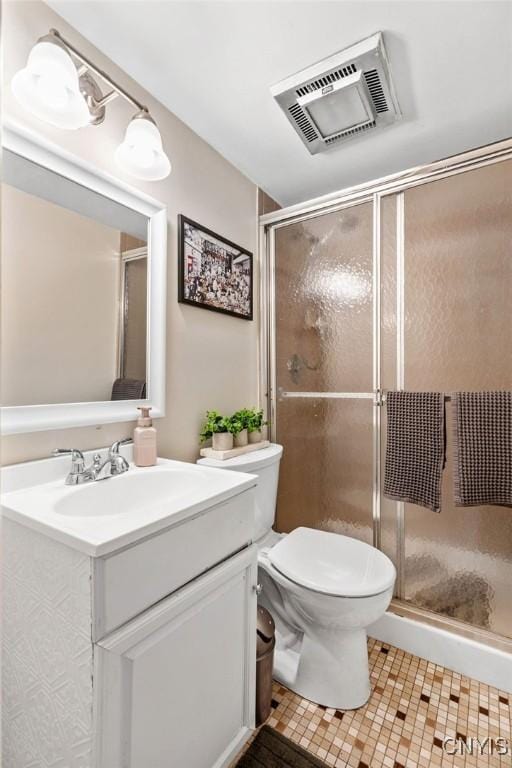 bathroom with a stall shower, visible vents, vanity, and toilet