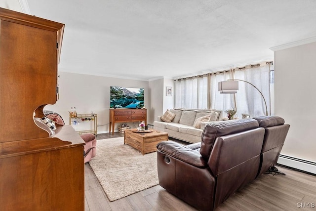 living area featuring a baseboard heating unit, ornamental molding, and wood finished floors