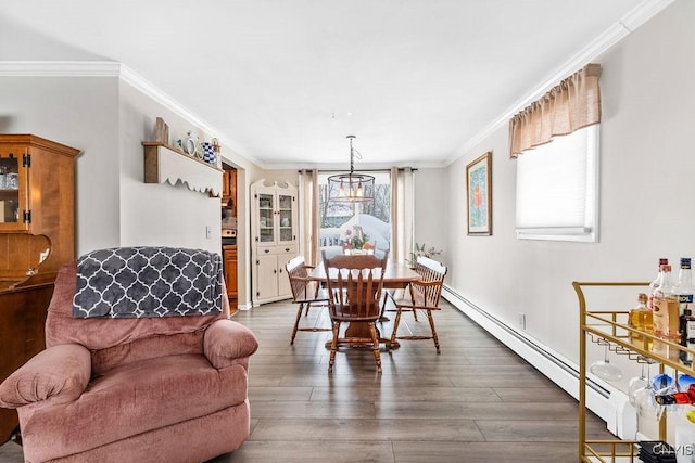 dining area featuring a baseboard heating unit, dark wood finished floors, crown molding, and a chandelier