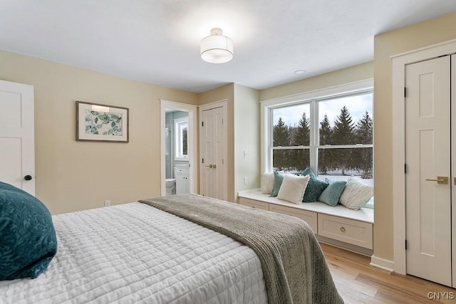 bedroom with light wood finished floors and baseboards