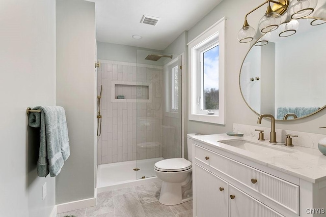 bathroom with toilet, vanity, visible vents, baseboards, and walk in shower