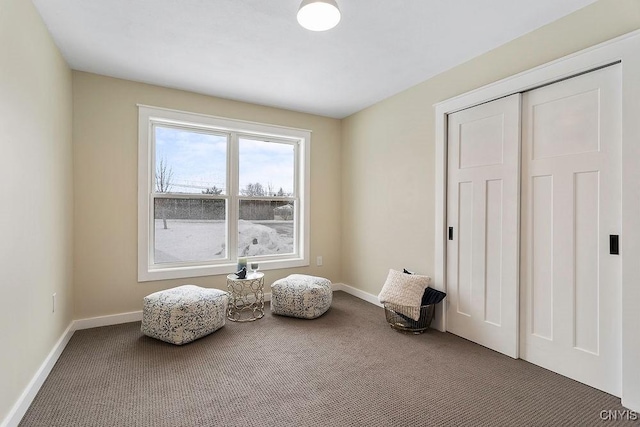 sitting room with dark carpet and baseboards