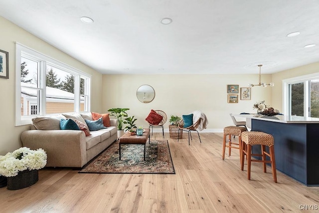 living area featuring light wood-style floors, baseboards, a chandelier, and recessed lighting