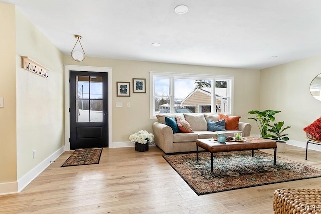 foyer with light wood-style flooring and baseboards