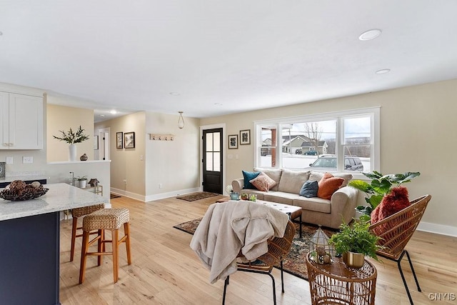 living room featuring recessed lighting, light wood-type flooring, and baseboards